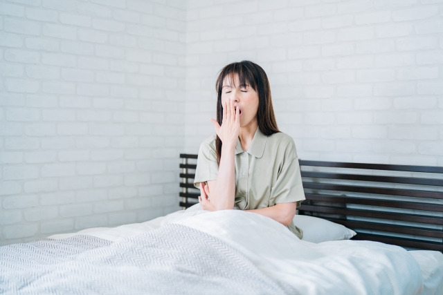 睡眠不足の女性(睡眠が不足すると、脂肪を分解する成長ホルモンの分泌が減少します。また、食欲を増進させるホルモンの分泌が増えて、食欲を抑えるホルモンの分泌が減ることで食べ過ぎてしまうことも。)